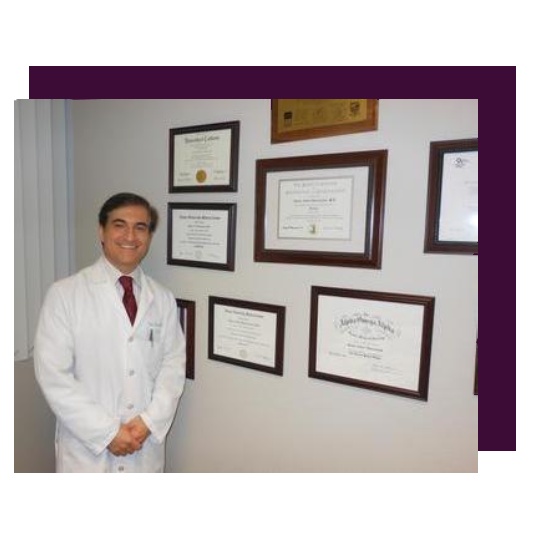 A man in white lab coat standing next to several certificates.